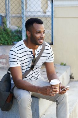 Siyahi bir adam, şehirde düşünmek için kahve ve telefon, sosyal medya ve açık havada görüş için internet. Erkek, daktilo ve uygulama planlama için şehirde iletişim, sohbet ve molada yolculuk için çay.