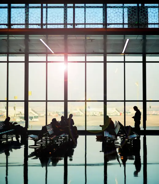 stock image People, travellers and waiting area in silhouette at airport lounge for business, vacation or immigration. Group, layover and departures for flight, trip and travel for destination, terminal or delay.