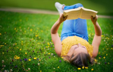 Doğa, kitap okumak ve kadınlar öğrenmek, bilgi edinmek ya da hafta sonu tatili için parkta dinlenirler. Üniversite, öğrenci ve kadın edebiyat, konfor ya da bahçede huzur için çimenlerin üzerinde uzanan kişi.