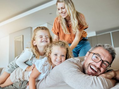 Salonda kaynaşma, aile ve portre, ebeveynler ve kızlarına, kızlarına ve eğlencesine duyulan aşkla mutlu. Ev, çocuklar ve anne oturma odasında, çocuklu kadın ve erkek, ilgi ve oyun için gülümseyin ve kucaklayın..