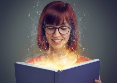 Glowing pages, book and woman with a story, fantasy and education on grey studio background. Person, reader and girl with a novel and literature with knowledge or creativity with glasses or astrology. clipart