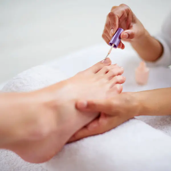 stock image Foot, hands and nail polish for pedicure closeup with treatment, skin and dermatology with makeup at spa. Beauty, wellness and people with cosmetics product for color, self care and cosmetology.