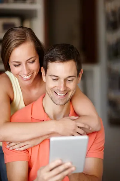 stock image Couple, hug and happy in home with tablet for streaming online for movies or films, videos and social media memes. Man, woman and together with hug for bonding or love with affection and support.