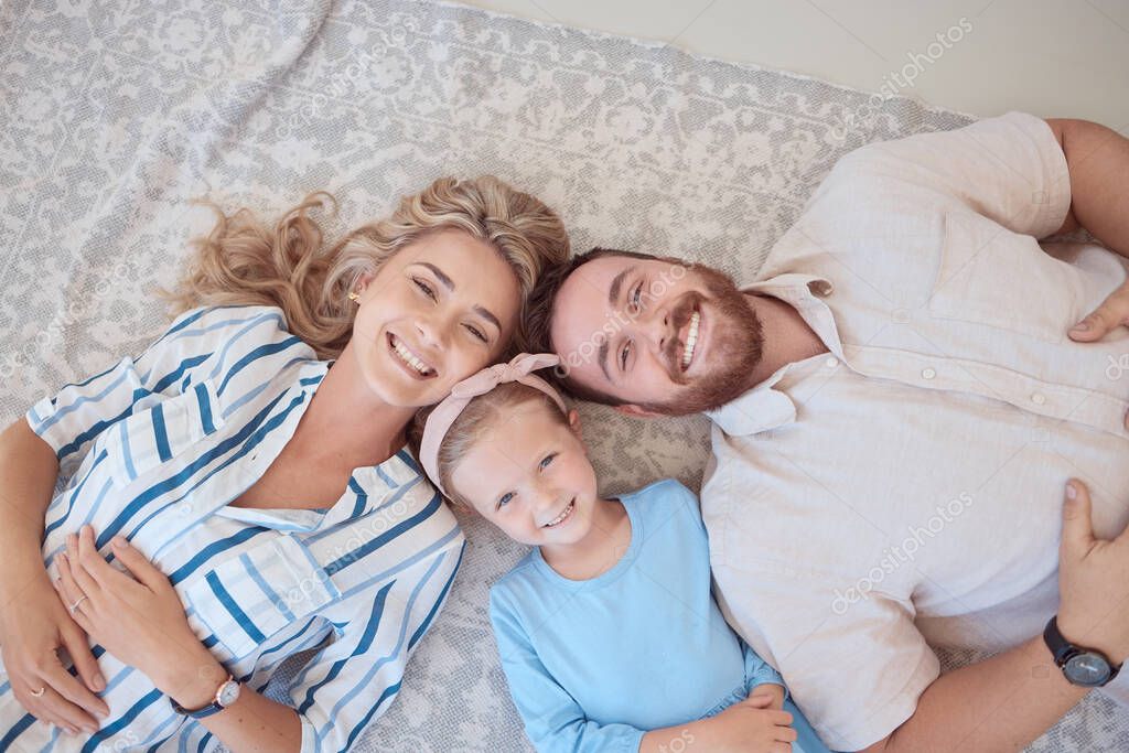 Portrait, happy and family in above on floor to relax for love, bonding and care with connection on weekend. Smile, parents and child rest with affection, security and trust together at house.