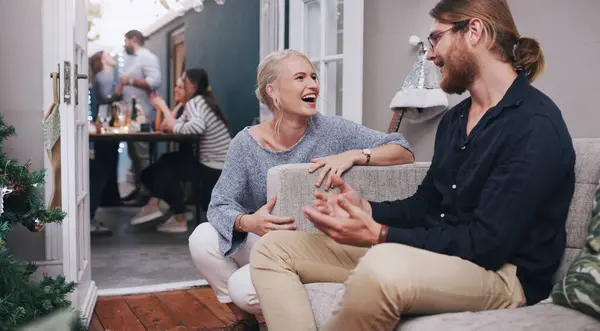 stock image Man, woman and talking at dinner party with friends for holiday celebration, living room or laughing. People, chatting and home or festive vacation for New Years lunch or funny, joke or socializing.