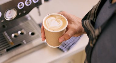 Hand, person and coffee at cafe in kitchen with cup in startup business and entrepreneur. Barista, restaurant and cappuccino from above to serve customer with steam, hot and fresh with machine. clipart