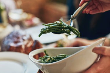 Green beans, festive and thanksgiving with hand of person dishing vegetables from dish in home closeup. Celebration, food and roast meal with guest at dinner party for event or social gathering. clipart