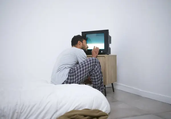 stock image Mental health, hospital and man in asylum, watching tv or brainwashed with depression. Television, patient and person with schizophrenia, bipolar disorder or sick in psychiatric clinic for psychology.