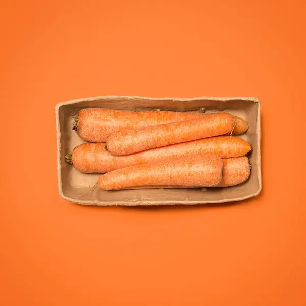 stock image Carrots, vegetable and studio on orange background as ingredient for cooking, nutrition and diet. Food, organic and vegetarian with healthy meal for wellness, health and self care with vitamins.