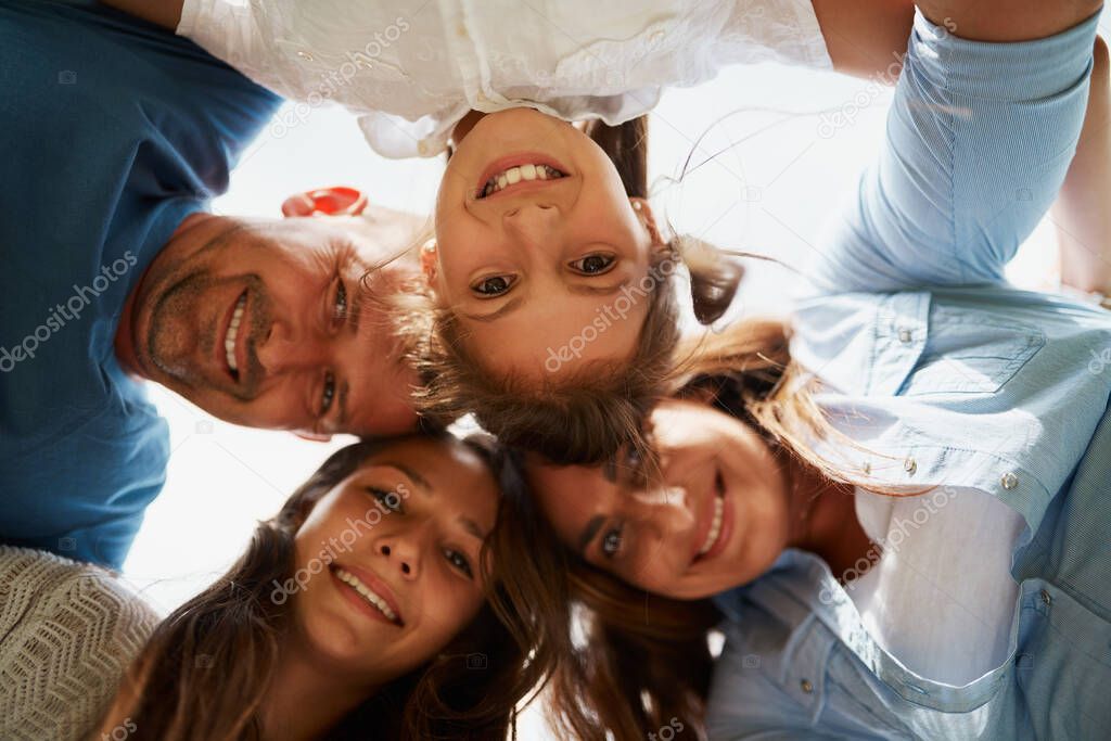Huddle, family and smile in embrace, portrait and low angle of group, outdoor and bonding in outing. Happy, people and parents with love for children, woman and man with girls, daughter and together.