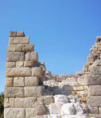 Old city, wall and blue sky for history, road trip and turkey tourism travel with castle ruin. Myndos Gate, destination and scenery with stone, bricks and view for Bodrum summer adventure or explore. clipart