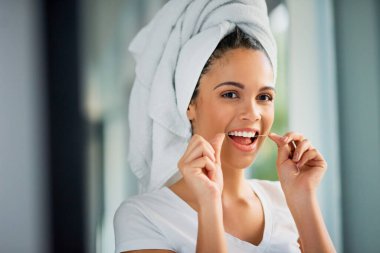 Oral health, smile and flossing of teeth, woman and dental hygiene for cleaning of mouth and grooming. Happy, routine and refresh in morning, person and towel in bathroom and getting ready in home. clipart