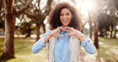 Portrait, outdoor and woman with heart hands, support and nature with kindness, trust and care. Face, person and girl in park, gesture and happiness with emoji, sign and symbol for love and smile. clipart