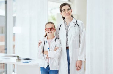 Portrait, doctor and girl with smile for career day in hospital with confidence for healthcare and future. People, education and smile at clinic for dressing up as professional for job shadowing. clipart