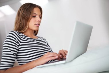 Typing, laptop and woman on sofa for freelancing, reading blog or relax in home lounge. Hybrid work, computer and online for research, writing email or language translation for social media platform. clipart