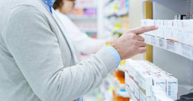 Person, hands and pharmacy with shelf for medication, symptoms or side effects at dispensary. Closeup, patient or client pointing for selection, choice or pick for health supplements at drug store. clipart