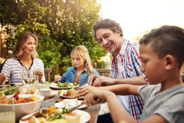 Mom, dad and kids at outdoor lunch with smile, celebration and happy family eating together in backyard. Father, mother and children at table for garden picnic with food, fun and bonding on patio clipart