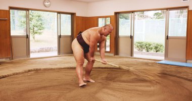 Broom, dohyo and sand with Sumo wrestler sweeping arena in mawashi, getting ready for competition. Cleaning, preparation and start with Japanese person for culture, heritage or martial arts tradition. clipart