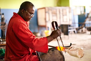 Glass, blowing and black man in bottle workshop for small business, craft or handmade technique. Creative, product shape or glassblower in factory for sustainable process, design or sculpture art. clipart