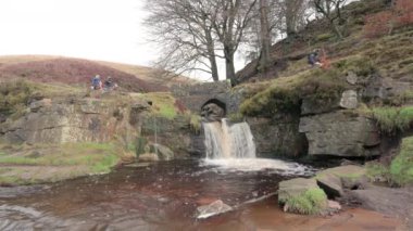 Off-road motosikletleri şelalenin üzerinde yeşil astar ve Three Shires Head 'deki Three Shires Head at taşı köprüsü, İngiltere, İngiltere' deki Peak District Ulusal Parkı 'nda..