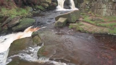 Şelalelerin kırsal manzarasının yukarı doğru çekimleri ve İngiltere 'nin Peak District Ulusal Parkı' ndaki Three Shires Head 'deki taş köprüleri gözler önüne seriliyor..