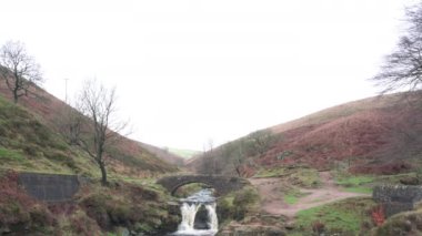 Şelalelerin ve Three Shires Head 'deki taştan köprülerin İngiltere, İngiltere' deki Peak District Ulusal Parkı 'ndaki kırsal kışın manzara görüntülerini gözler önüne seriyor..