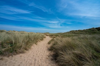 Talacre 'daki kum tepeleri ve plaj Kuzey Galler, İngiltere' de güneşli bir yaz gününde popüler bir turizm beldesi..