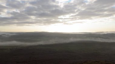 İngiltere, İngiltere 'deki Peak District Ulusal Parkı' ndan yükselen sis, sis ve mor fundanın hava görüntüsü..