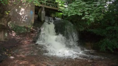 Miras Yolu 'nun bir parçası olan Slitting Mill, Rugeley, İngiltere ve İngiltere' deki Boynuz Havuzu şelalesi ve taş köprü..