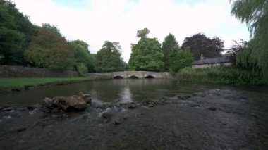 İngiltere, İngiltere 'deki Derbyshire Tepesi Ulusal Parkı' nda Ashford 'da bulunan üç kemerli koyun yıkama köprüsünden akan Wye Nehri' nin B rulosu kilitlendi..