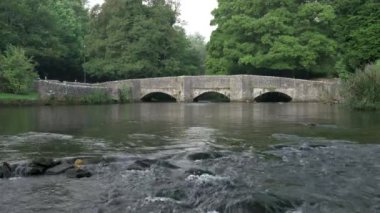 İngiltere, İngiltere 'deki Derbyshire Tepesi Ulusal Parkı' nda Ashford 'da bulunan üç kemerli koyun yıkama köprüsünden akan Wye Nehri' nin B rulosu kilitlendi..