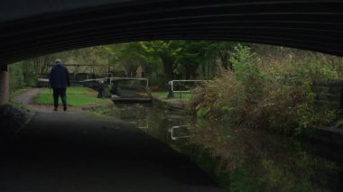 STOKE-ON-TRENT, STAFFORDSHIRE, ENGLAND - 30 Ekim 2024: Caldon Kanalı 'nda kilit açan erkek ve kadın bir çocuk dar kayık dizisi 3' ün 1 'ini kullanırken.