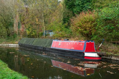 FROGHALL, STAFFORDSHIRE, ENGLAND - 11 Kasım 2024: Harabe bir ev ve Froghall Rıhtımı yakınlarındaki eski harap tekne tarafından Caldon Kanalı 'na demirlenmiş dar bot.