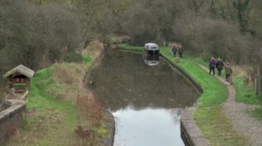 DENFORD, STAFFORDSHIRE, ENGLAND - 12 Kasım 2024: İnsanlar sonbahar boyunca İngiltere 'nin Staffordshire kenti yakınlarındaki Caldon Kanalı' nın Leek kolunda yürüyorlar.