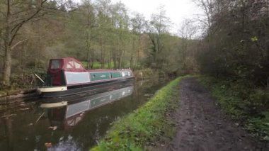 FROGHALL, STAFFORDSHIRE, ENGLAND - 11 Kasım 2024: Harabe bir ev ve Froghall Rıhtımı yakınlarındaki eski harap tekne tarafından Caldon Kanalı 'na demirlenmiş dar bot.