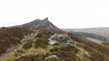 Sinema insansız hava aracı görüntüleri kayalık bir kış tepesi manzarası üzerinde hızla alçaktan yere uçuyor..