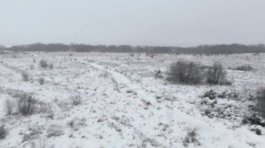 Staffordshire Moorlands sinemasal düşük yavaş hava aracı uçuşu engebeli kırsal kış manzarası üzerinde hafif kar tozu eşliğinde.