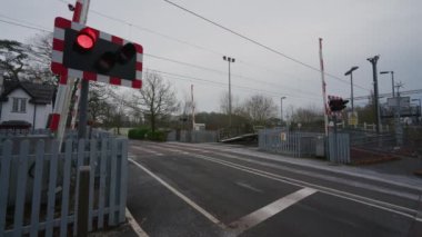 BARLASTON, STAFFORDSHIRE, İNGİLTAN - 8 HAZİRAN 2025 Uyarı ışıkları yanıp sönüyor ve Wedgwood kavşağında trafik yaklaşırken sınır kapakları kapanıyor.