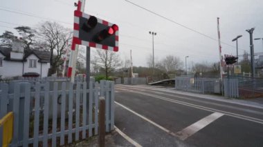 BARLASTON, STAFFORDSHIRE, İNGİLTAN - 8 HAZİRAN 2025: DPD kurye minibüsü bariyerler kapanmadan hemen önce bir geçidi geçiyor.
