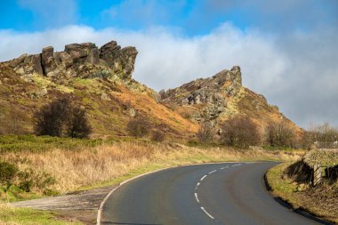 A sunny winters day roadside view of Ramshaw Rocks in the Staffordshire Peak District National Park, England, UK. clipart