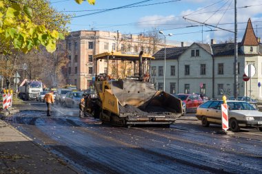 Şehirdeki yol onarımı çalışmaları: asfalt güneşli bir sonbahar gününde sokakta yenileniyor