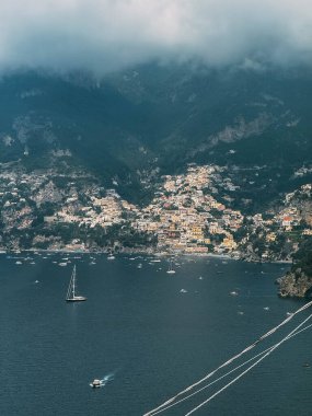 Arka planda büyük bir su kütlesi olan güzel bir şehir. Su sakin ve gökyüzü bulutlu.