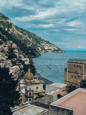 Kilisesi ve plajı olan güzel bir şehir manzarası. Kumsal teknelerle dolu ve su sakin.