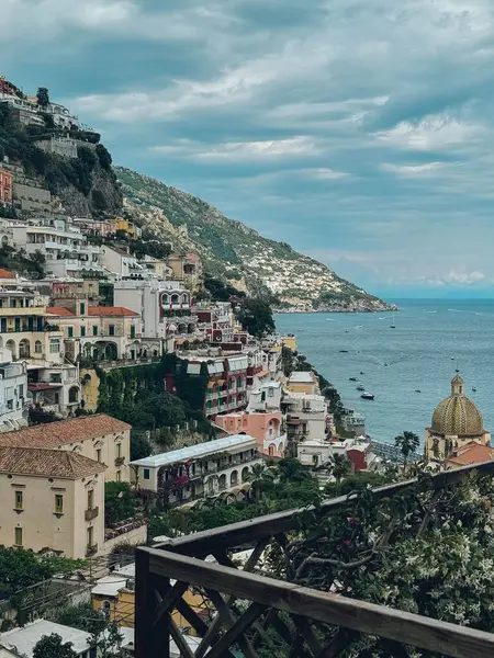 Arka planda büyük bir su kütlesi olan güzel bir şehir manzarası. Binalar yüksek ve bir sürü pencereleri var. Bu da kalabalık bir kentsel alan izlenimi veriyor. Gökyüzü bulutlu.