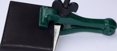 Cüzdanı kapalı ve kilitlenmiş bir klemp ve bir dolar banknotu olan bir cüzdan görüntüsü. Mevcut kriz ve tasarruflara referans