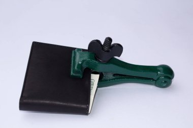 Cüzdanı kapalı ve kilitlenmiş bir klemp ve bir dolar banknotu olan bir cüzdan görüntüsü. Mevcut kriz ve tasarruflara referans