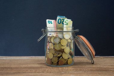 Bir kavanoz dolusu bozuk para ve dökülen banknotlar..