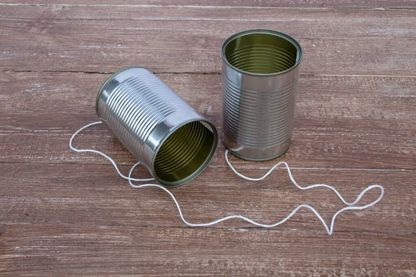 Image of two jars tied with string. Game for children to talk remotely. Mechanical jar telephone.