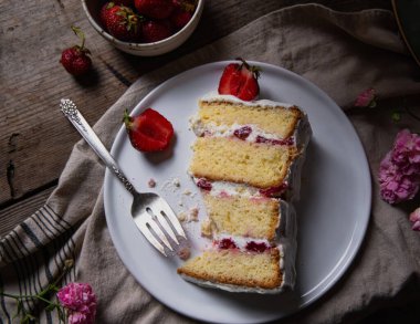 Çatal ve çilekli bir tabakta bir pasta resmi. Yemek ve kek fotoğrafları..
