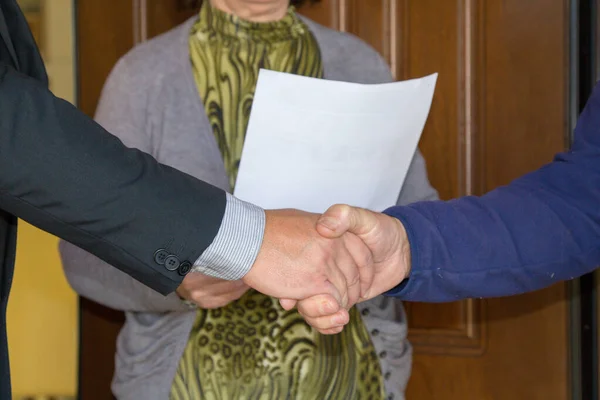 Image of two men shaking hands after concluding a deal. Creation of a sales contract.